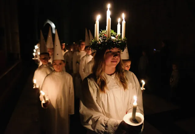 Matilda Jarl, 15, from the Jarfalla chamber choir near Stockholm, Sweden plays the role of Lucia as she leads the procession during the Swedish Sankta Lucia Festival of Light service at York Minster on December 9, 2016 in York, United Kingdom. The Sankta Lucia service is a traditional Swedish service merged from pagan and christian traditions. Celebrating Saint Lucy who was a young Sicilian girl martyred for her Christian faith in the early 4th century it celebrates the bringer of light during the long darkness of winter. This service incorporates a candlelit procession of choristers led by a young girl, Lucia, wearing a crown of candles on her head and a red sash around her waist. The crown of candles is thought to symbolise a halo and the red sash martyrdom. Lucia is followed by her attendants and the starboys. This is the fourth time the procession has been held at York Minster and is run in conjunction with the York Anglo-Scandinavian Society. (Photo by Ian Forsyth/Getty Images)