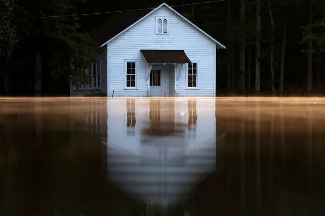 Mist rises off the water as a flooded building is pictured after Hurricane Matthew passes in Lumberton, North Carolina, October 11, 2016. (Photo by Carlo Allegri/Reuters)