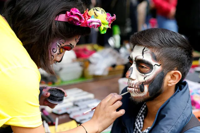 A man has his face painted as “Catrina”, a Mexican character also known as “The Elegant Death”, as he takes part in a Catrina parade ahead of the Day of the Dead in Mexico City, Mexico, October 21, 2018. (Photo by Andres Stapff/Reuters)