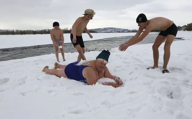 Zinaida Bulygina (bottom), 65, and local children, members of a winter swimmers family club, warm up before swimming in the icy waters of the Tuba river in the Kuragino village, southeast of the Russian Siberian city of Krasnoyarsk, March 17, 2015. The “Ldinka” (Ice Floe) club, founded by Zinaida Bulygina, a former champion of the USSR in winter marathon swimming, in 1993 is the first winter swimmers association in the countryside districts of the region. (Photo by Ilya Naymushin/Reuters)