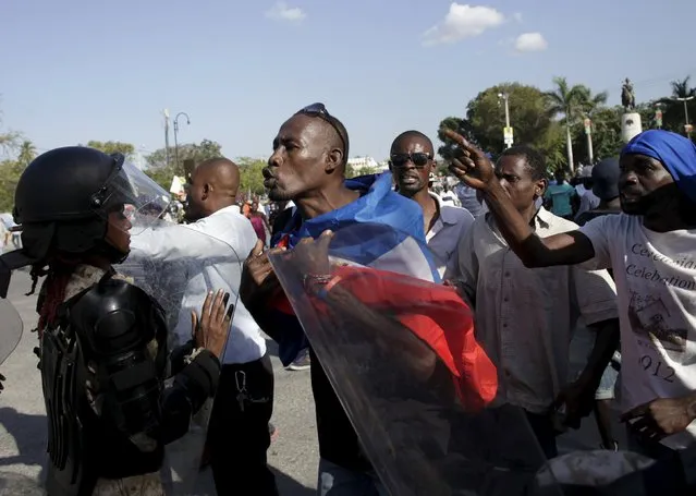 Protesters argue with National Police officers as they march to protest against the government and the electoral process in Port-au-Prince, Haiti, January 29, 2016. (Photo by Andres Martinez Casares/Reuters)