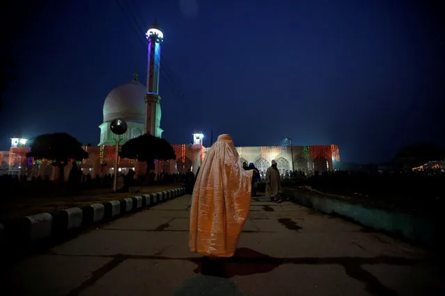 A woman wearing a traditional veil begs at the Hazratbal shrine during the festival of Eid-e-Milad-ul-Nabi, the birth anniversary of the prophet, in Srinagar November 21, 2018. (Photo by Danish Ismail/Reuters)