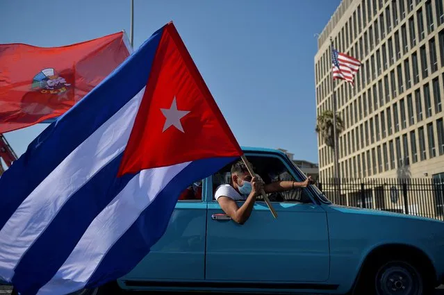 Cubans drive past the US embassy during a rally calling for the end of the US blockade against Cuba, in Havana, March 28, 2021 (Photo by Yamil Lage/AFP Photo)