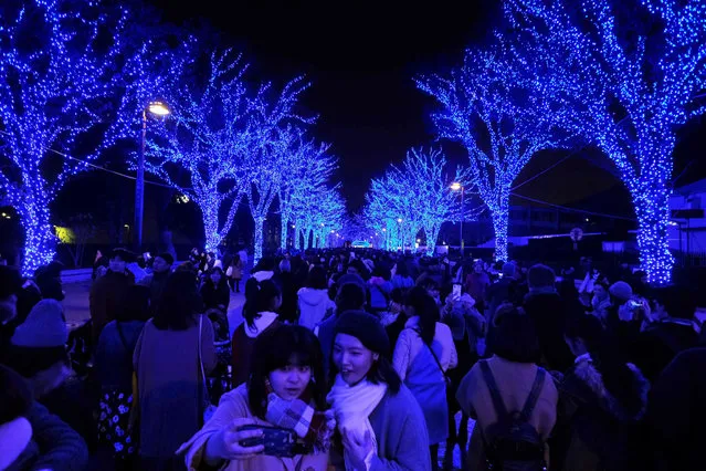 People walk under winter illuminations featuring a theme of “Blue Cave” at Yoyogi Park in Tokyo on December 16, 2018. (Photo by Kazuhiro Nogi/AFP Photo)