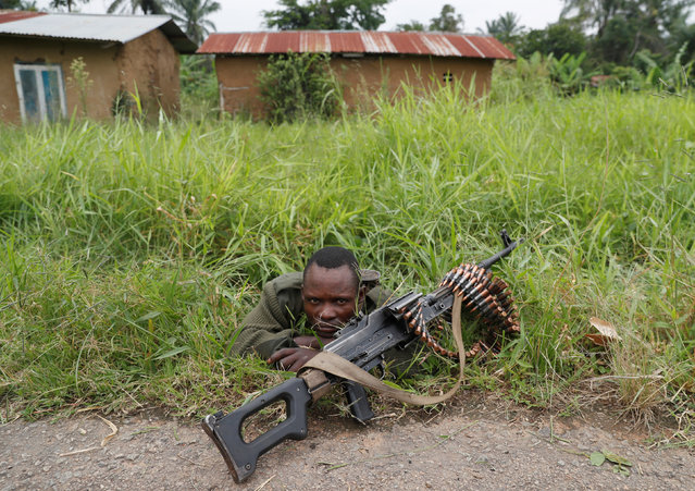 An Armed Forces of the Democratic Republic of the Congo (FARDC) soldier rests next to a road after Islamist rebel group called the Allied Democratic Forces (ADF) attacked area around Mukoko village, North Kivu province of Democratic Republic of Congo on December 11, 2018. (Photo by Goran Tomasevic/Reuters)