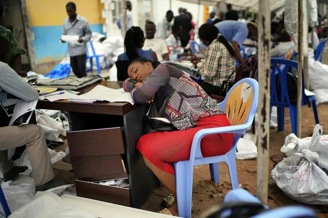 An exhausted Congolese independent electoral commission (CENI) official rests as results are tallied for the presidential election, at a local results compilation center in Kinshasa, Congo, Sunday, January 6, 2019. The winner of the December 30 election will not be made public Sunday as expected, the head of the national electoral commission Corneille Nangaa told The Associated Press. The electoral commission will confirm the delay later Sunday. (Photo by Jerome Delay/AP Photo)