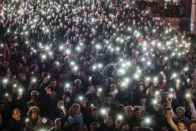 People hold up their smartphones as they take part in a demonstration in Artvin, northeastern Turkey, to protest against the controversial plans to build a gold and copper mine in the ecologically pristine area, on February 23, 2016. Environmental organisations have branded the planned mine “illegal”. The plan for the mine had initially been blocked by the Turkish judiciary, but it was finally approved after environmental impact reports gave the go-ahead to the project. (Photo by Yasin Akgul/AFP Photo)
