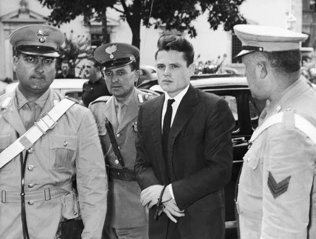 American jazz trumpeter Chet Baker, handcuffed and escorted by Italian carabinieri (State police) arrives at a Florence Court of Appeals, for a hearing on September 7, 1961 of his appeal against a sentence of 18 months in jail, for smuggling narcotics into Italy for his own use. Baker's Chicago defense attorney, Joseph Carani, told the court that Baker bad already been in jail a year and 15 months and now could be considered cured of the drug habit. (Photo by Giulio Torrini/AP Photo)