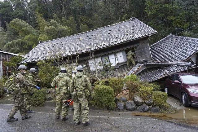 Japanese Self Defense Force members inspect a collapsed house hit by earthquakes in Suzu, Ishikawa prefecture, Japan Wednesday, January 3, 2024. Rescue workers and canine units urgently sifted through rubble Wednesday ahead of predicted freezing cold and heavy rain in what the prime minister called a race against time after powerful earthquakes in western Japan killed multiple people. Dozens are believed trapped under collapsed buildings. (Photo by Kyodo News via AP Photo)