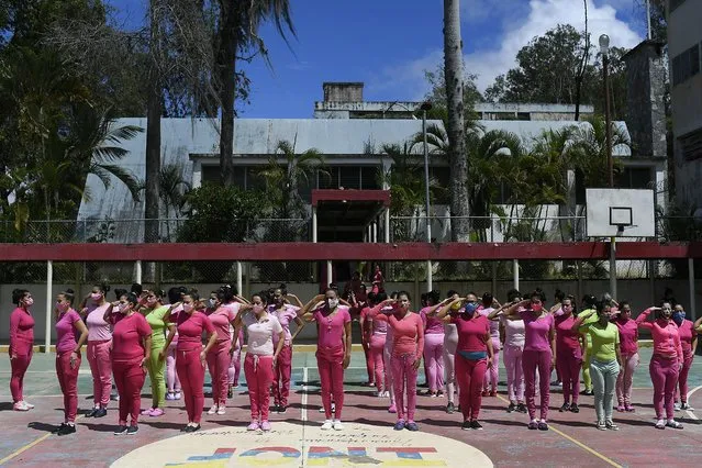 Inmates salute standing in formation as they prepare to be inoculated with the Sinopharm COVID-19 vaccine during a vaccination campaign at the women's prison in Los Teques, Miranda state, Venezuela, Friday, July 2, 2021. (Photo by Matias Delacroix/AP Photo)