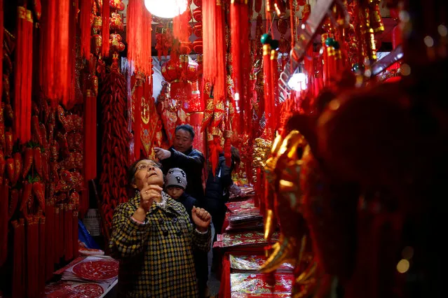 A customer looks at traditional decorations for the upcoming Chinese Lunar New Year, at a shopping area, in Shanghai, China January 18, 2017. (Photo by Aly Song/Reuters)
