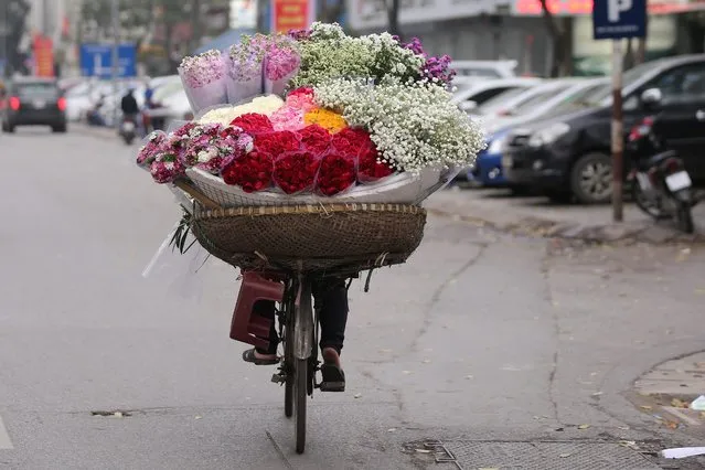 Street vendors sell flowers on the street, in Hanoi, Vietnam, 07 March 2016. International Women's Day is marked on 08 March every year and Vietnamese men usually offer flowers to women. (Photo by Luong Thai Linh/EPA)