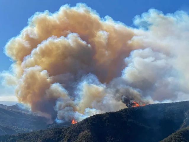 In this photo provided by Santa Barbara County Fire Department, the Alisal Fire continues to burn the dry vegetation in Refugio Canyon on Tuesday morning, October 12, 2021,  in Santa Barbara County, Calif.  (Photo by Mike Eliason/Santa Barbara County Fire via AP Photo)