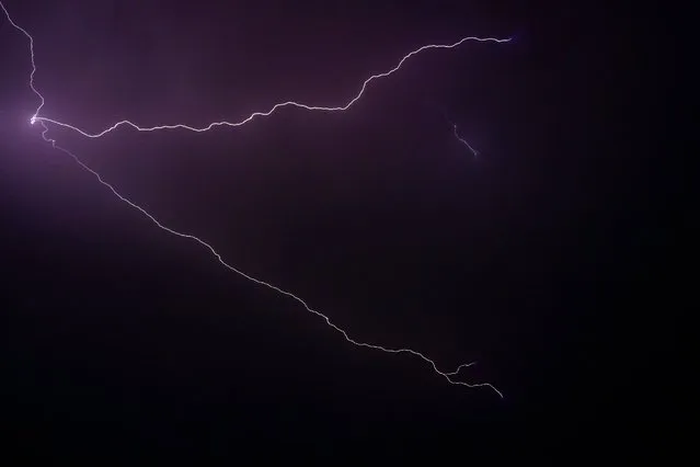 Lightning strikes through the sky over the Srinagar city on September 20, 2021. (Photo by Tauseef Mustafa/AFP Photo)