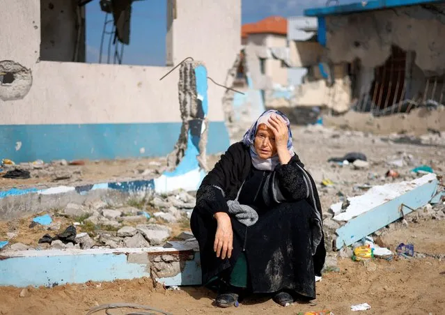 A woman rests next to a damaged building, as Palestinian arrive in Rafah after they were evacuated from Nasser hospital in Khan Younis due to the Israeli ground operation, amid the ongoing conflict between Israel and Hamas, in the southern Gaza Strip, on February 15, 2024. (Photo by Mohammed Salem/Reuters)
