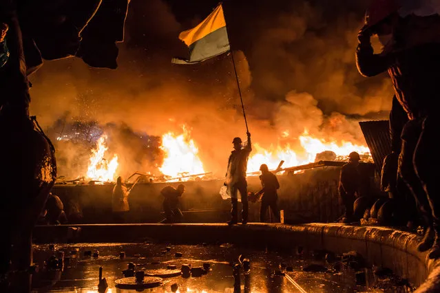 Anti-government protesters guard the perimeter of Independence Square, known as Maidan, on Tuesday in Kiev, Ukraine. Police in Ukraine's capital attacked an opposition camp that's been the center of the massive anti-government protests that began last November. (Photo by Brendan Hoffman/Getty Images)