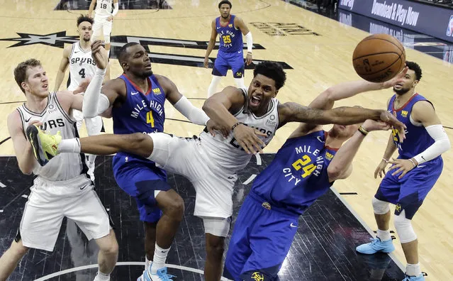 San Antonio Spurs forward Rudy Gay (22) is fouled as he drives to the basket against Denver Nuggets forward Mason Plumlee (24) and forward Paul Millsap (4) during the second half of Game 3 of an NBA basketball playoff series in San Antonio, Thursday, April 18, 2019. San Antonio won 118-108. (Photo by Eric Gay/AP Photo)