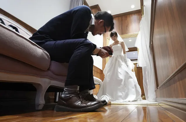 In this April 11, 2019, photo, Kenzo Watanabe smiles as his fiancee Chiharu Yanagihara tries on a wedding dress at a Japanese wedding company in Tokyo. Japan is getting ready for its biggest celebration in years with the advent of the Reiwa era of soon-to-be emperor Naruhito. That means big opportunities for businesses hoping consumers will splash out on long holidays and memorabilia. (Photo by Eugene Hoshiko/AP Photo)