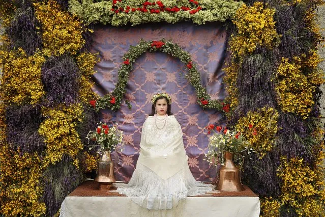 A “Maya” girl sits in an altar during the traditional celebration of “Las Mayas” on the streets in Colmenar Viejo, near Madrid, Spain Saturday, May 2, 2015. (Photo by Daniel Ochoa de Olza/AP Photo)