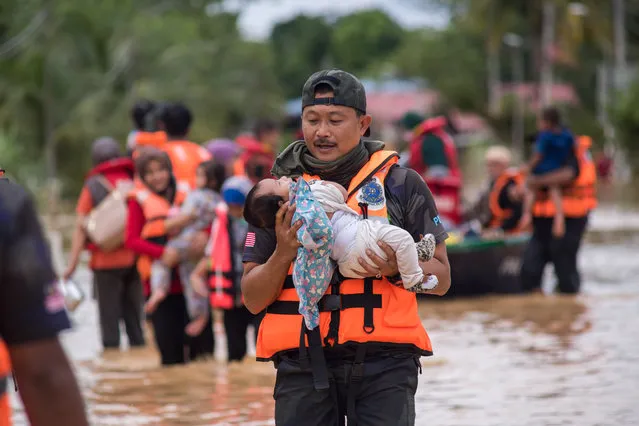 Rescuers evacuate flood victims in Hulu Langat, Selangor, Malaysia, December 19, 2021. Thousands of people were evacuated as continuous heavy rain caused severe flooding in several parts of Malaysia, Prime Minister Ismail Sabri Yaakob said late on Saturday. (Photo by Xinhua News Agency/Rex Features/Shutterstock)