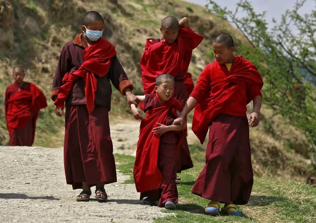 Young monks take a break from their studies at Changangkha Lhakhang temple in Thimphu, Bhutan, April 13, 2016. (Photo by Cathal McNaughton/Reuters)