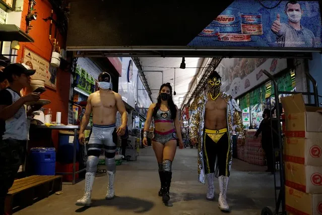 Lucha libre wrestlers, Sussy love, Bandido, and Gravity along with others arrive to encourage mask-less people to wear masks to aid the prevention against the coronavirus at the Central Abastos market, in Mexico City, Mexico on March 10, 2021. (Photo by Carlos Jasso/Reuters)