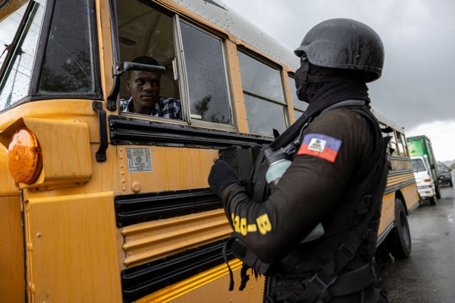 A Haitian National Police officer stops a bus at a security checkpoint in Limonade, Haiti on April 27, 2024. (Photo by Ricardo Arduengo/Reuters)