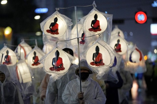 A Buddhist carries lanterns and walk in a parade during the Lotus Lantern Festival, ahead of the birthday of Buddha at Dongguk University in Seoul, South Korea, Saturday, May 11, 2024. (Photo by Ahn Young-joon/AP Photo)