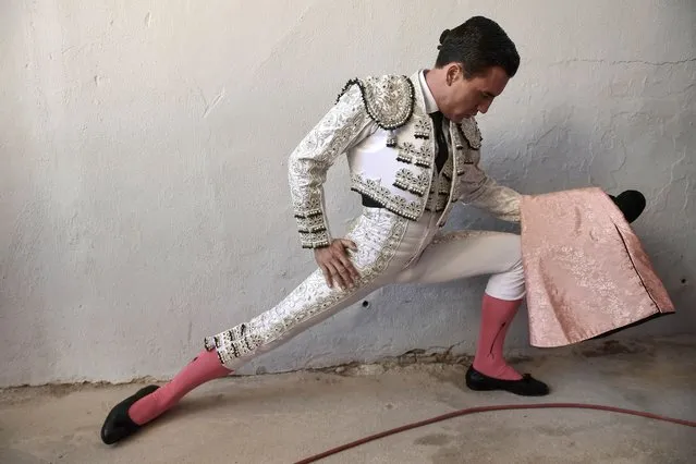 Spanish bullfighter Octavio Chacon warms up before entering the bullring at the San Fermin Festival in Pamplona, northern Spain, Sunday, July 14, 2018. Revelers from around the world flock to Pamplona every year to take part in the eight days of the running of the bulls, and say good bye today with the sing “Pobre de Mi” in the midnight. (Photo by Alvaro Barrientos/AP Photo)