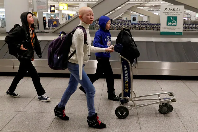 Emmanuel Rutema, Pendo Noni, and Mwigulu Magesa (L to R), Tanzanians with Albinism visiting the U.S. for medical care, walk through JFK International Airport after arriving in New York City, U.S., March 25, 2017. (Photo by Brendan McDermid/Reuters)