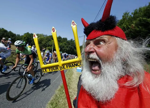 The pack of riders makes its way past Didi Senft, a cycling enthusiast better known as “El Diablo” (The Devil), during the twelfth 218km stage of the centenary Tour de France cycling race from Fougeres to Tours July 11, 2013. (Photo by Eric Gaillard/Reuters)