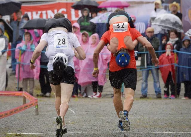 Competitors participate in the annual Wife Carrying World Championships in Sonkajaervi, Finland, 04 July 2015. The event took place for the 20th time. (Photo by Kimmo Brandt/EPA)
