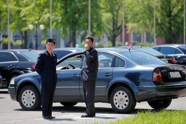 Men stand by black vehicles with the 727 number plates, reserved for the highest government officials, outside the People's Palace of Culture in central Pyongyang, North Korea May 8, 2016. (Photo by Damir Sagolj/Reuters)