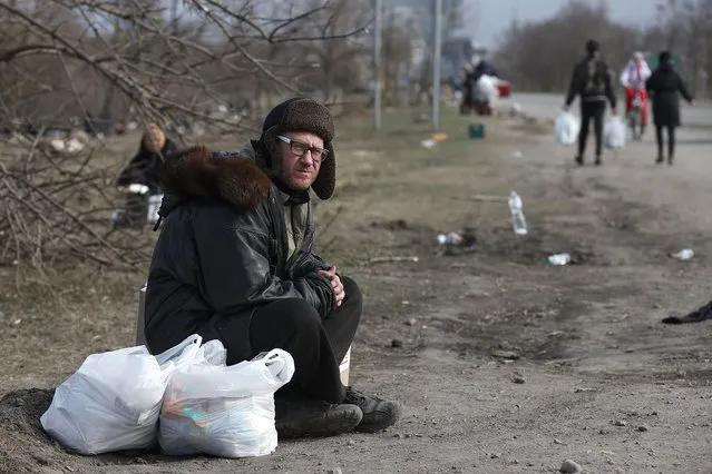 A man sits by the roadside in Mariupol, Ukraine on March 20, 2022. Tensions started heating up in Donbass on February 17, with the Donetsk and Lugansk People's Republics reporting the most intense shellfire from Ukraine in months. Early on February 24, President Putin announced the start of a special military operation by the Russian Armed Forces in response to appeals for help from the leaders of both republics. (Photo by Mikhail Tereshchenko/TASS)