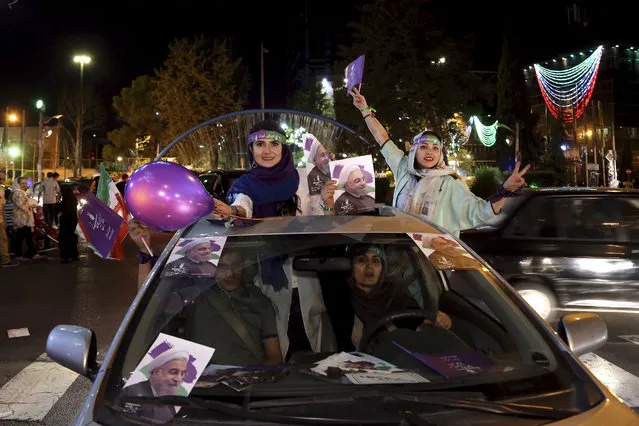 Supporters of Iranian President Hassan Rouhani attend a street campaign ahead the May 19 presidential election in downtown Tehran, Iran, Wednesday, May 17, 2017. President Hassan Rouhani, a moderate, is seeking re-election in a vote that will largely serve as a referendum on his outreach to the West, which culminated in the 2015 nuclear deal with world powers. (Photo by Ebrahim Noroozi/AP Photo)