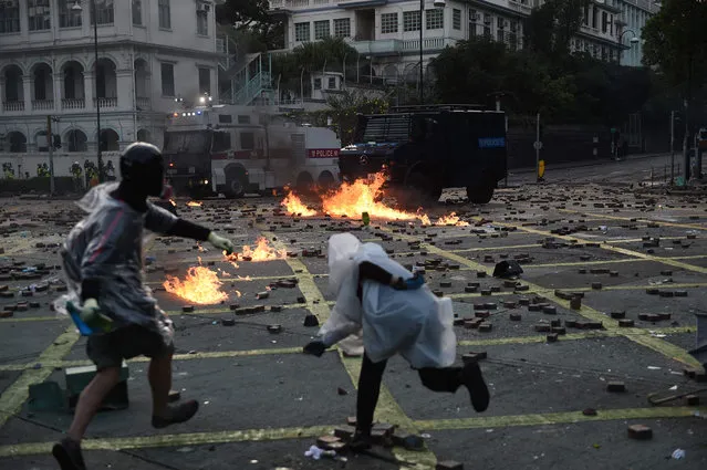 Protesters throw molotov cocktails at the police outside the Hong Kong Polytechnic University in Hong Kong on November 17, 2019. Hong Kong police clashed with pro-democracy activists who vowed to “squeeze the economy” as the increasingly divided city reels from one of the worst weeks of violence in the months-long crisis. (Photo by Ye Aung Thu/AFP Photo)