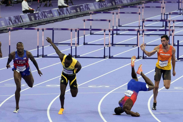 Grant Holloway, left, of the United States, wins the men's 110-meters hurdles final as teammate Daniel Roberts, takes a tumble at the line, at the 2024 Summer Olympics, Thursday, August 8, 2024, in Saint-Denis, France. (Photo by Martin Meissner/AP Photo)