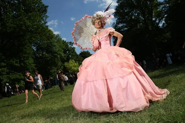 A male visitor in a pink dress inspired by European historic fashion attend the Victorian Picnic on the first day of the annual Wave-Gotik-Treffen (WGT) Goth music festival on June 2, 2017 in Leipzig, Germany. The annual event is among the largest Gothic festivals in the world and draws approximately 20,000 enthusiasts from all over Europe from Goth, Cybergoth, Steampunk, Rivethead and Punk influences. The four-day festival includes performances by 200 bands as well as cultural outings including cemetery strolls and cathedral sermons. (Photo by Sean Gallup/Getty Images)
