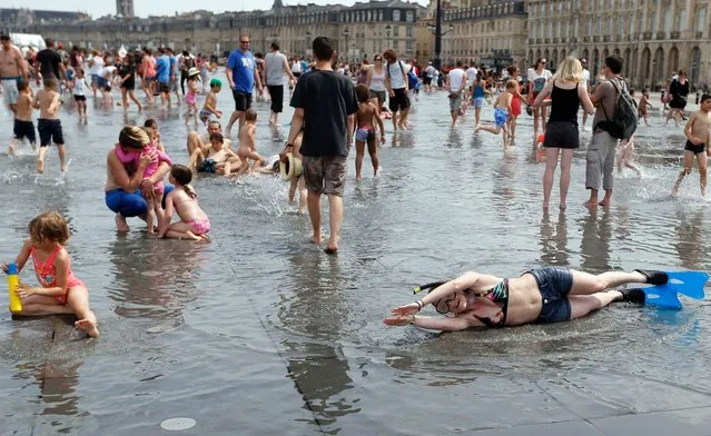 People enjoy the good weather during a warm summer day on the banks of the Garonne and the place de la Bourse in Bordeaux centre, southwestern France June 22, 2014. (Photo by Regis Duvignau/Reuters)