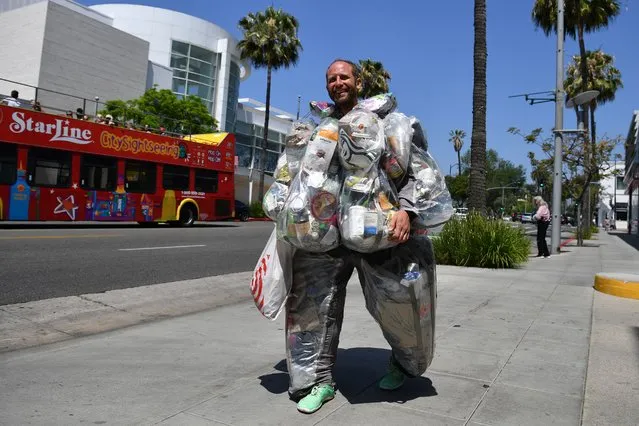 Environmental activist Rob Greenfield walks around Beverly Hills, California on May 16, 2022 wearing a suit filled with every piece of trash he has generated living and consuming like a typical American for one month to raise awareness about how much garbage just one person generates. Greenfield is currently on day 27 of the 30-day project and is wearing 63 lbs (28,5kg) of trash. We all know someone with a rubbish fashion sense, but Rob Greenfield is proud to be wearing garbage – it's all part of a plan to show just how much trash we unthinkingly throw away every month. The campaigner is wandering the streets of Los Angeles and surrounding cities in a specially designed suit that holds all of the junk he has produced over the last few weeks. (Photo by Robyn Beck/AFP Photo)
