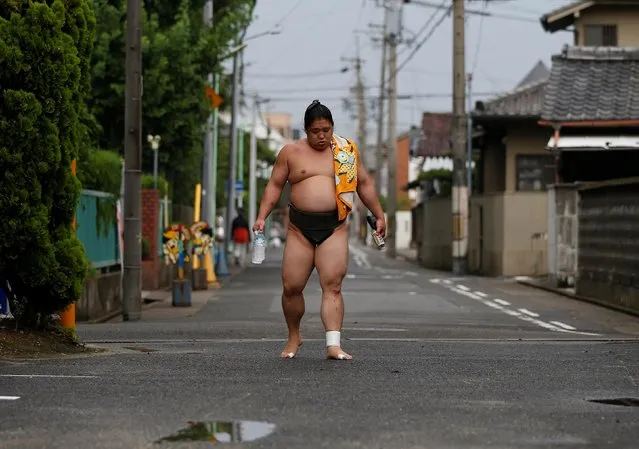 Sumo wrestler Kainishiki returns to training at Ganjoji Yakushido temple in Nagoya, Japan on July 18, 2017. Full assimilation into Japanese culture means that foreign wrestlers face no ill-will. “We wear our topknots, kimonos and sandals, and live by Japanese rules, and the rules of sumo”, said Tomozuna Oyakata. “It's only by chance that we were born a different nationality”. (Photo by Issei Kato/Reuters)
