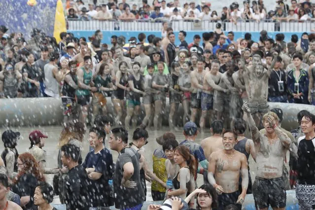 Festival-goers take a bath in a mud pool during the 20th Boryeong Mud Festival on Daecheon beach in Boryeong City, some 190 kilometers west of Seoul, South Korea, 22 July 2017. (Photo by Jeon Heon-Kyun/EPA/EFE)