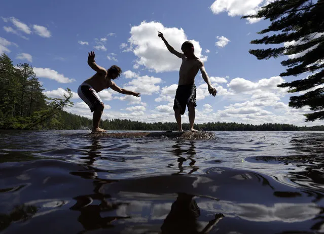 Ben Boschetto of Wayland, Mass., left, and Wes Bell of Fort Ann, N.Y., try to force each other into the water while log birling on Lower St. Regis Lake at the Adirondack Woodsmen's School at Paul Smith's College on Thursday, July 10, 2014, in Paul Smiths, N.Y. (Photo by Mike Groll/AP Photo)