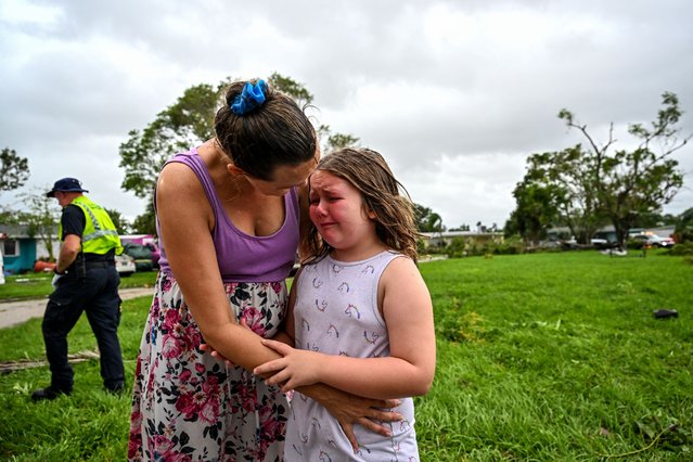 Samantha Dubberly consoles her daughter Alexa Haight as medics takes her grandfather into care after he got injured by a reported tornado that hit his house in Fort Myers, Florida on October 9, 2024, as Hurricane Milton approaches. Florida residents fled or just hunkered down in the final hours October 9 before Milton pummels the state, as government emergency relief efforts were dragged to the center of the US election. (Photo by Chandan Khanna/AFP Photo)