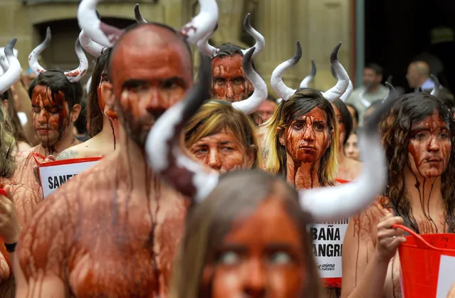 Animal rights protesters covered in fake blood demonstrate for the abolition of bull runs and bullfights a day before the start of the famous running of the bulls San Fermin festival in Pamplona, northern Spain, July 5, 2016. (Photo by Eloy Alonso/Reuters)