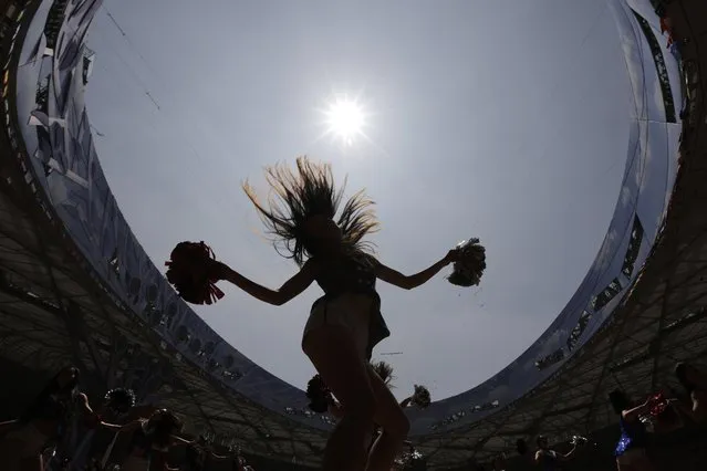 Cheerleaders are silhouetted as they rehearse on the track at the Bird's Nest Stadium in preparation for the upcoming World Athletics Championships in Beijing Thursday, August 20, 2015. (Photo by Andy Wong/AP Photo)