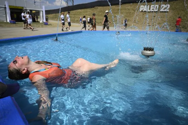 Festivalgoer Sarah cools off in a water fountain amid a heatwave in the country, on the first day of the 45th edition of the Paleo Festival, in Nyon, Switzerland, 19 July 2022. The Paleo is the largest open-air music festival in the western part of Switzerland  and runs from 19 to 24 July. (Photo by Laurent Gillieron/EPA/EFE/Rex Features/Shutterstock)