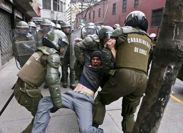In this Thursday, August 24, 2017 photo, a high school student is detained by police during a protest in Santiago, Chile. High school students marched to demand the acceleration of the government transfer of 5,000 public schools from local municipalities to state entities. (Photo by Esteban Felix/AP Photo)