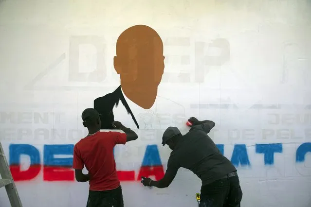 Artists paint a portrait of slain Haitian President Jovenel Moise near the presidencial residence where he was assassinated in the Petion-ville area of Port-au-Prince, Haiti, Thursday, July 7, 2022. A year has passed since Moise was assassinated at his private home. (Photo by Odelyn Joseph/AP Photo)