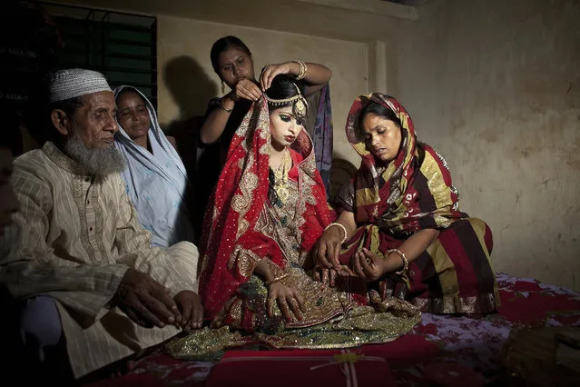 15 year old Nasoin Akhter sits with relatives while posing for photos on the day of her wedding to a 32 year old man, August 20, 2015 in Manikganj, Bangladesh. In June of this year, Human Rights Watch released a damning report about child marriage in Bangladesh. The country has one of the highest rates of child marriage in the world, with 29% of girls marrying before the age of 15, and 65% of girls marrying before they turn 18. (Photo by Allison Joyce/Getty Images)